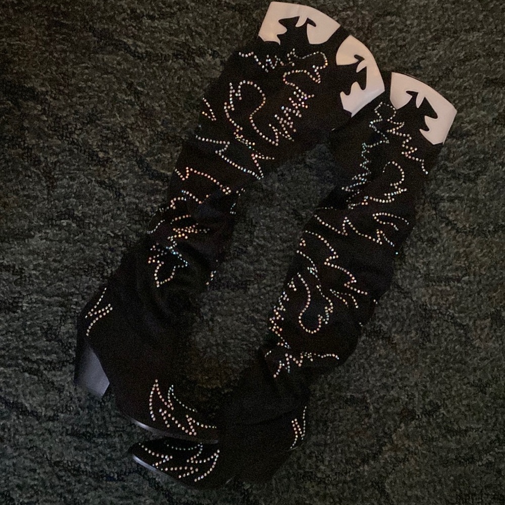 Black and white thigh high “cowboy” boots.